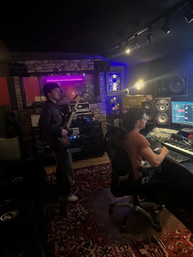 Gus recording bass tracks with vocals.